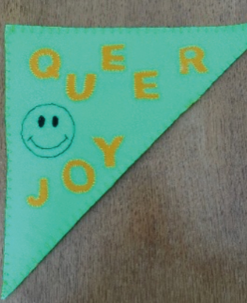 A Pride pendant banner showing the words Queer Joy